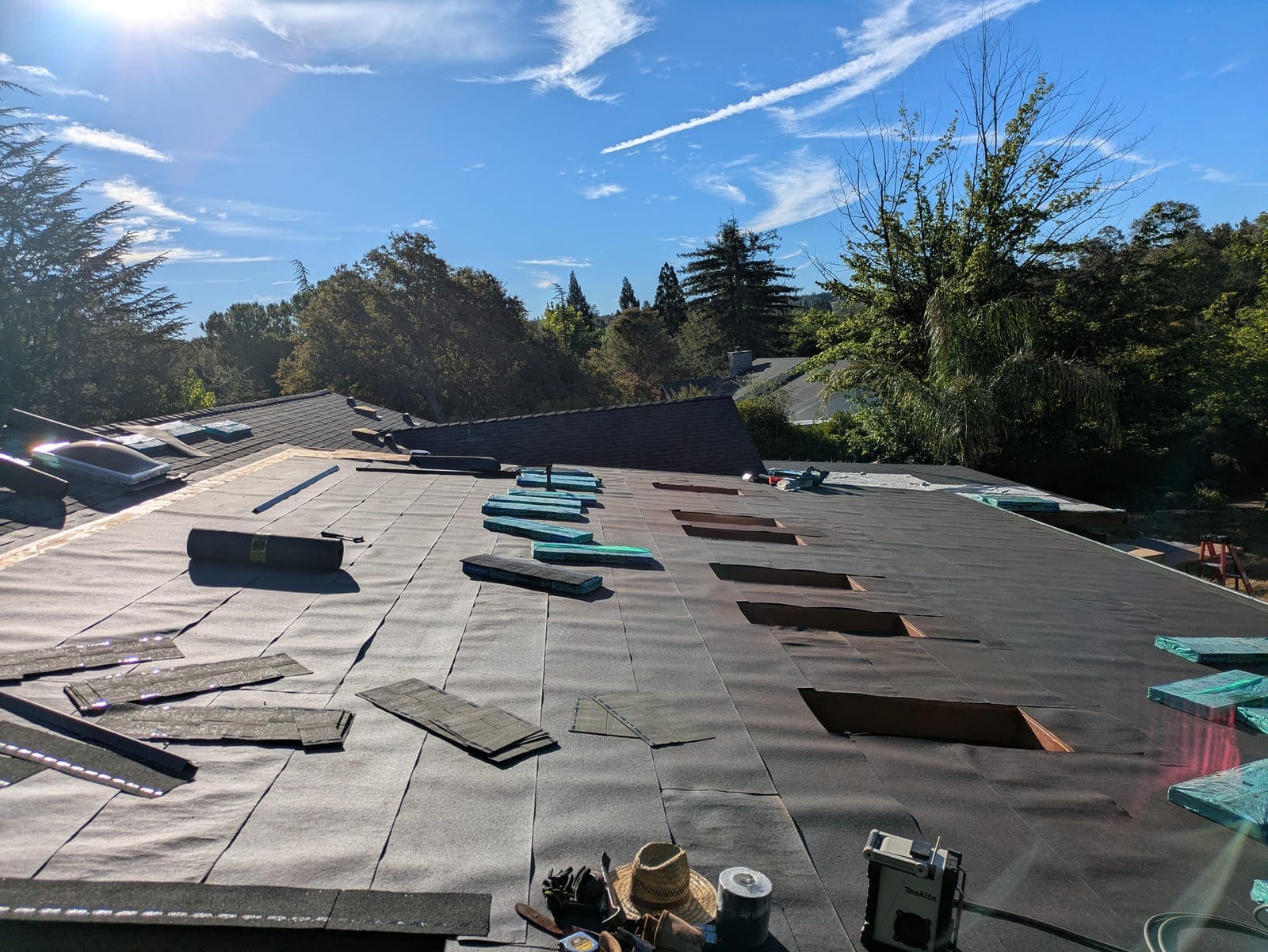 First shingle courses started at the roof edge with materials staged above