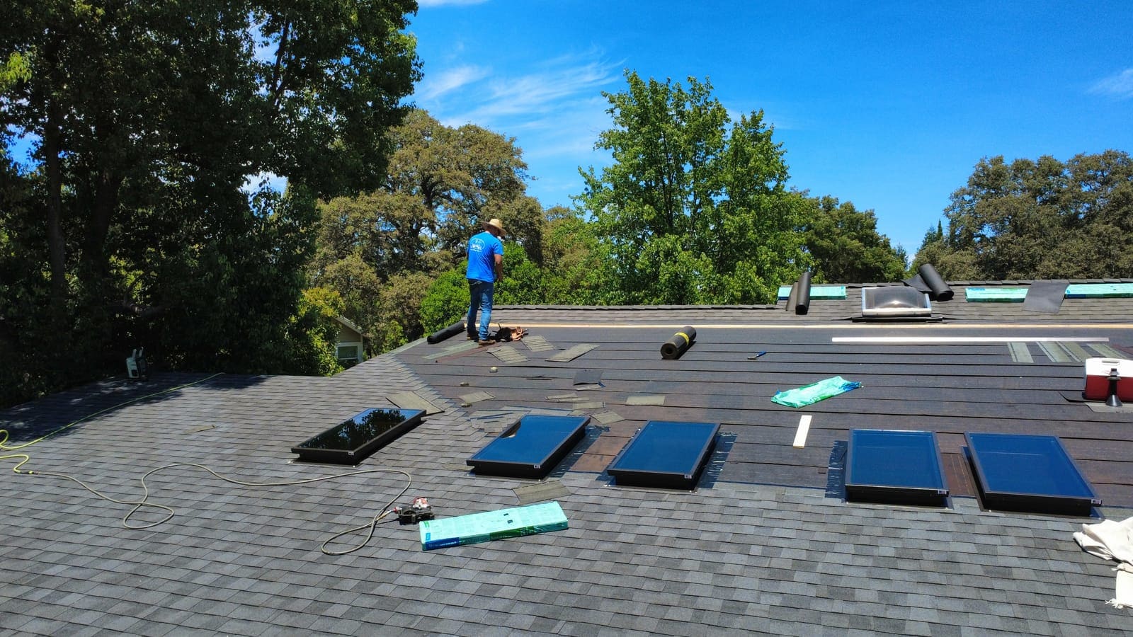 New shingles installed across the roof with skylights set in place